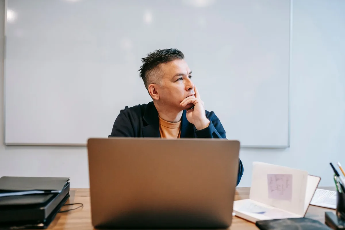 Focused businessman in home office, pondering work thoughts. Perfect for remote work and telecommuting concepts.